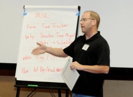 An instructor at an IFL event presents his group’s ideas on how to integrate teaching resources from ABMP into business curriculum to improve students’ time-management skills.