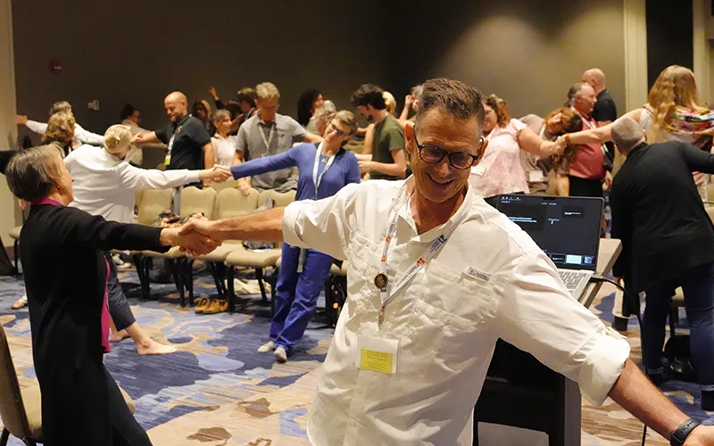 Til Luchau takes part in a stretching exercise in a conference room at the 7th Fascia Research Congress.