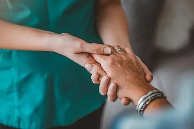 an MT holding and working with a person's hand.