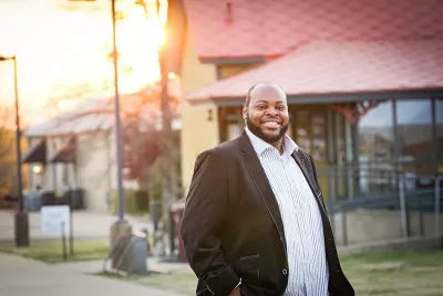 Terrance Bonner stands in a black jacket with a big smile on his face.