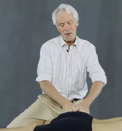 Erik Dalton's fists apply a fast-paced gluteal oscillating maneuver on the client.