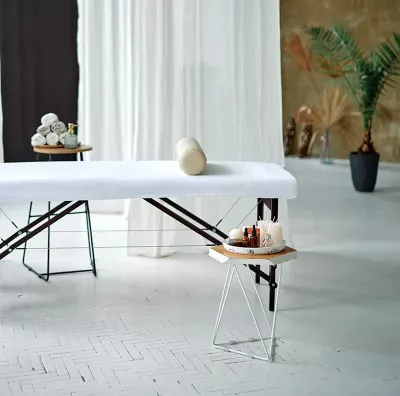 a shared space with a massage table with screens and drapes dividing the room.