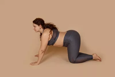 a woman in cow pose, her spine sagging.