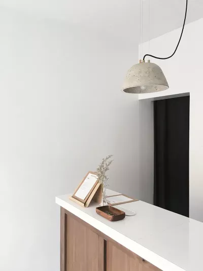 A hanging lamp over a white reception desk.
