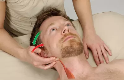 an MT following the SCM muscles on a male client's neck.