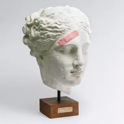 A bust with a bandage on the forehead.