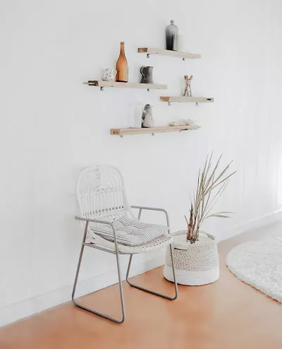 an empty waiting room with one chair and some wooden shelves. 
