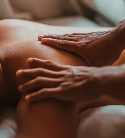 two hands of an MT on a person's left scapula region.