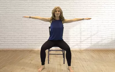 LMT angie parris-raney raising her arms up on both sides in a T shape.