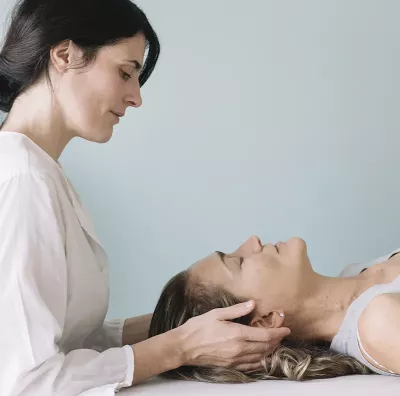 female MT working on the head of a female client.