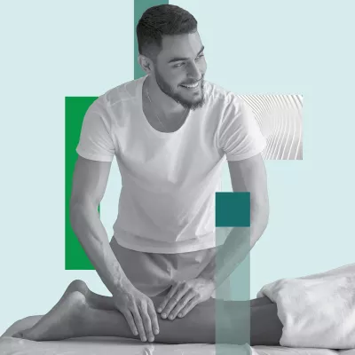 A massage therapist works on a prone client's lower leg.