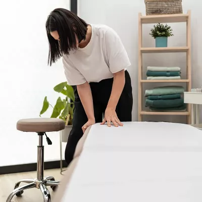 A massage therapist inspects her massage table.