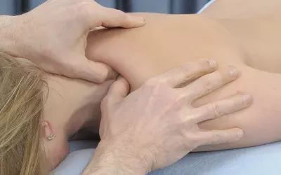 a massage therapist treating a patient's rotator cuff area