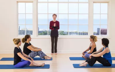 Judith Aston instructing in a yoga-like environment.
