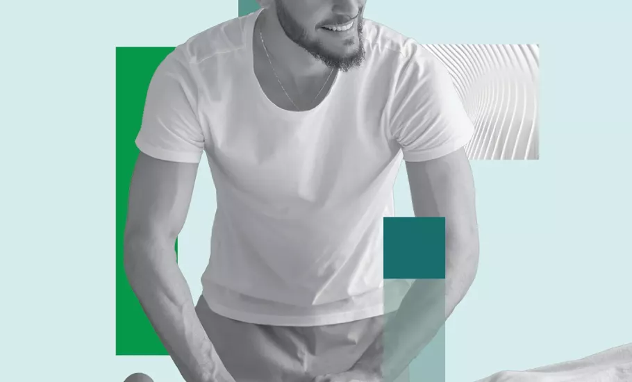 A massage therapist works on a prone client's lower leg.