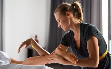 a female MT uses both her hands, arms, and elbows to massage a client.