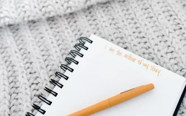 a blank notebook page with the words written "I am the author of my own story."