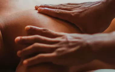 Two hands of an MT on a person's back.