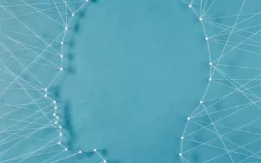 a web of string and needles connects to form the shape of a face. 