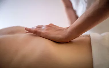 an MT's hand on the abdomen of a draped client.