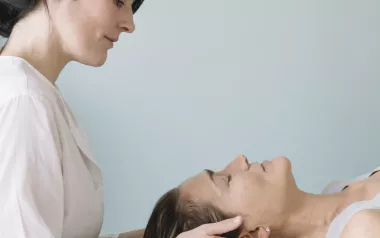 a female MT working on the head and neck area of a prone female client.