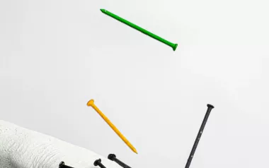 nails falling onto a statue of a human hand.