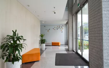 a modern office building hallway with orange couches and sunny light shining in.