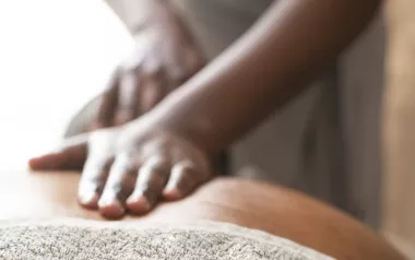 A Black MT lays flat palms on a client's back.