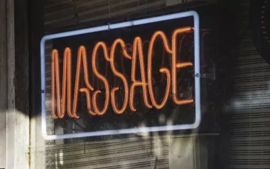 a neon fluorescent massage sign in a business window.