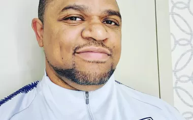 Desmond Diaz in a US Olympic team uniform smiles at the camera.