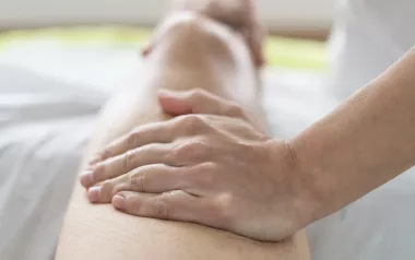 A massage therapists tends to a client's leg.