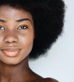 A Black woman smiles at the camera.