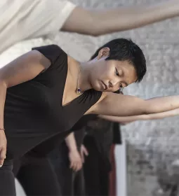 People go through movement exercises, balancing on one leg and extending one arm.