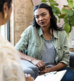 Two women, massage client and therapist, conduct a health intake.
