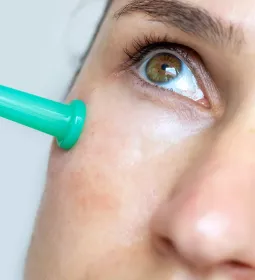Close up of a women's cheek with a small cupping tool in place.