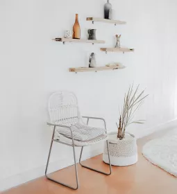 an empty waiting room with one chair and some wooden shelves.