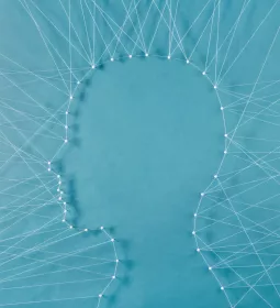 a web of string and needles connects to form the shape of a face.