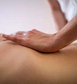 an MT's hand on the abdomen of a draped client.