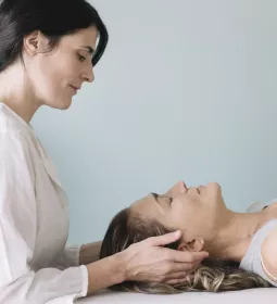a female MT working on the head and neck area of a prone female client.