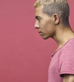 lateral view of a man in a pink shirt with his head and neck angled forward.