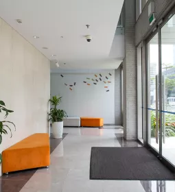 a modern office building hallway with orange couches and sunny light shining in.