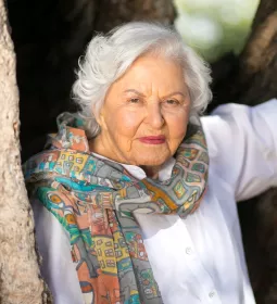 portrait of deborah szekely in her 80s. She's wearing a colorful scarf.