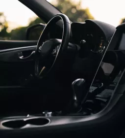 a steering wheel and a black drivers seat interior of a car.