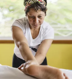 Woman massages the leg of a client.