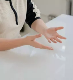 A person seated at a table, palms facing up.
