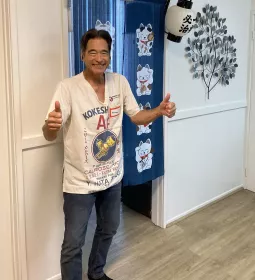 Jonathan Twidwell gives two thumbs up to the camera while standing in his studio.