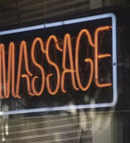 a neon fluorescent massage sign in a business window.
