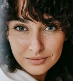 close up of a woman with brown hair looking at the camera.