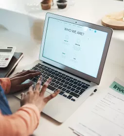 A person uses a laptop to create a website for their business.