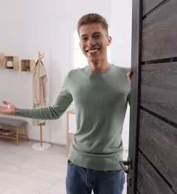 Welcoming male MT opens a door to a session room.